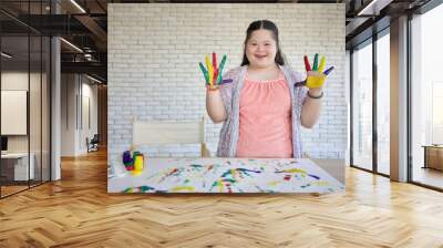 down syndrome teenage girl showing painted hands, drawing a picture on paper Wall mural