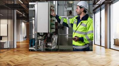 engineer or factory worker using tablet computer for finding how to use machine control panel in factory Wall mural