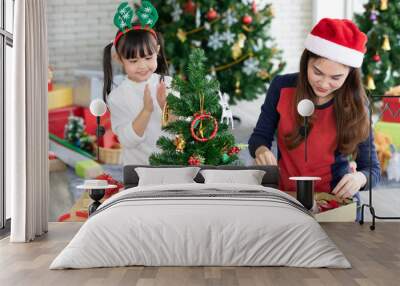 happy mother and daughter decorating christmas tree together Wall mural