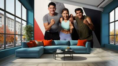 portrait group of young friends or trainers winner gesture after workout in the gym Wall mural