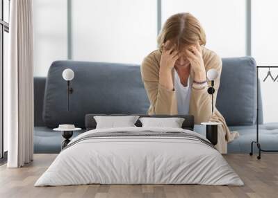 senior woman have a headache on a sofa Wall mural