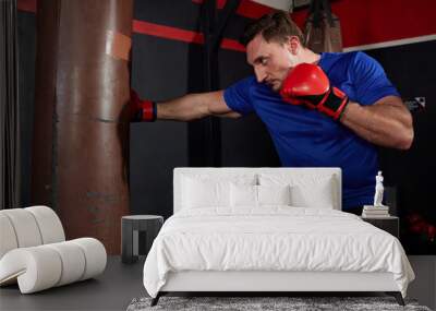 sportsman or fighter training boxing with punching bag in the gym Wall mural