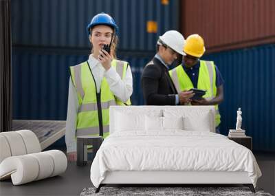 woman factory worker or engineer using walkie talkie for preparing a job in containers warehouse storage Wall mural