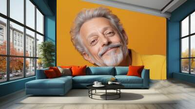 Elderly Hispanic man with a gentle and peaceful smile, wearing a casual shirt, against a pastel orange background Wall mural