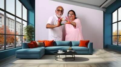 indian senior or old aged couple celebrating holi with colour  Wall mural