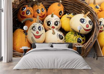 A full basket of decorative pumpkins with painted funny faces fo Wall mural