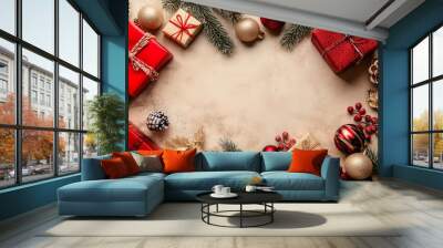 Festive christmas backdrop featuring fir branches, red and gold ornaments, presents, and pine cones against a beige background Wall mural