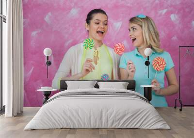 Two young women have fun with lollipops, celebrating party conce Wall mural