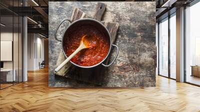 Classic homemade tomato sauce in the pan on a wooden chopping board on brown background, top view. Pasta, pizza tomato sauce. Vegetarian food Wall mural