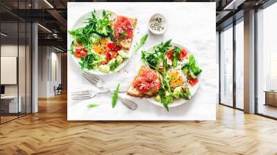 Delicious healthy breakfast - egg with vegetables, arugula salad and salmon cream cheese toast on a light background, top view Wall mural