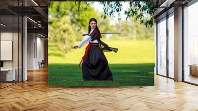 Young asian woman in traditional kimono trains fighting techniques with katana sword samurai warrior girl Wall mural