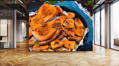 Close up baked roasted grilled whole orange pumpkin butternut squash and sweet potato slides with herbs on the baking sheet on blue napkin. Vegetarian and vegan food diet. Healthy eating concept. Wall mural