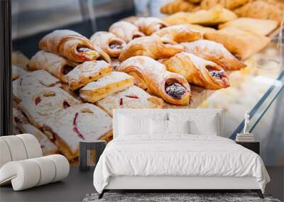 Close up freshly baked pastry goods on display in bakery shop. Selective focus Wall mural