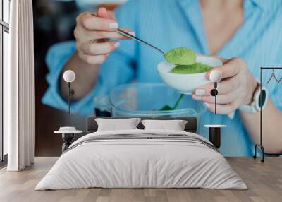 Close up woman adding wheat grass green powder during making smoothie on the kitchen. Superfood supplement. Healthy detox vegan diet. Healthy dieting eating, weight loss program. Selective focus Wall mural