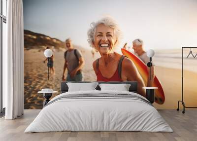 Laughing senior middle aged woman with gray hair and tattoos in sporty outfit walking on seaside beach with blurred aged friends in sunset. Aged people enjoy life. Active elderly people's lifestyle Wall mural