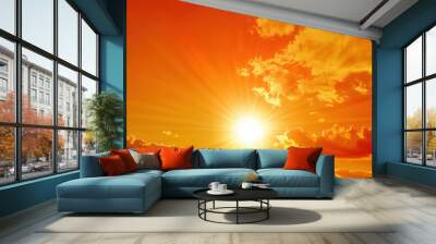 Sun shines brightly behind fluffy clouds in a fiery orange sky Wall mural