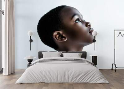 A close-up side view portrait of an African small boy with black skin against a white background, Wall mural