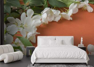 Greeting card with branches of apple blossom on an orange backgr Wall mural