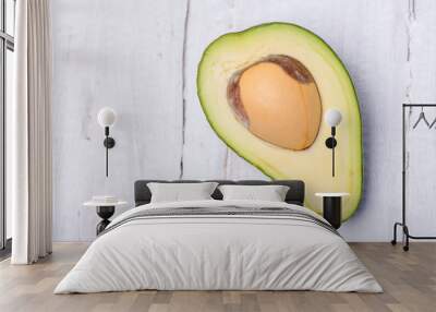 Juicy green avocado chopped on a wooden board on a white background Wall mural