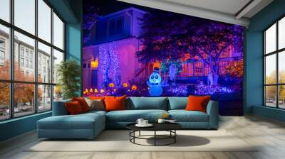 Illuminated night Halloween house outdoor decorations with colorful lights, lanterns, monsters and glow garlands Wall mural