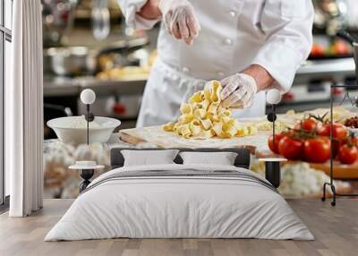 Italian chef demonstrating hand twisting pasta dough  step by step guide in masterclass Wall mural