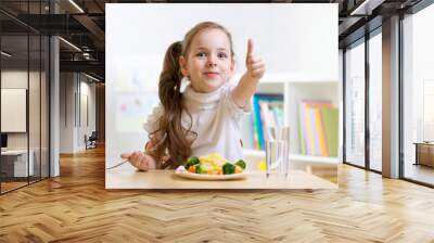 child eats healthy food showing thumb up Wall mural