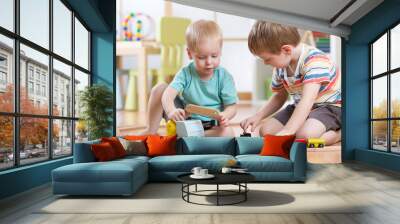 children boys playing railroad together in playroom Wall mural