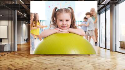 Children in the gym. Preschool kid girl with fitball in physical education lesson. Wall mural