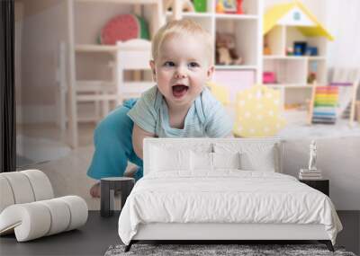 funny baby boy playing toy in nursery or kindergarten Wall mural