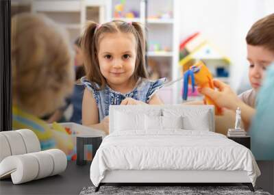 Group of kids playing with modeling clay in nursery Wall mural