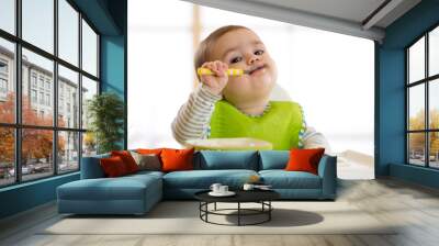 Happy baby boy spoon eats itself Wall mural