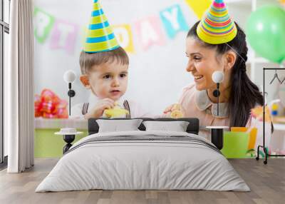 kid boy celebrating birthday holiday. mom looking happily to her Wall mural