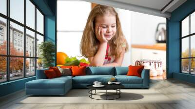 kid choosing between healthy vegetables and tasty sweets Wall mural