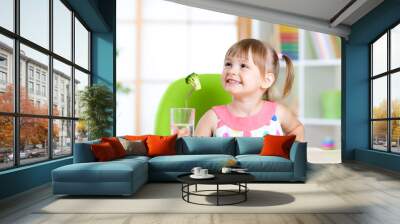 Kid eating healthy vegetables meal in home or nursery Wall mural