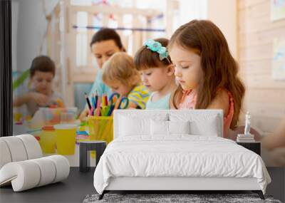 kindergarten children doing arts and crafts with teacher in day care centre Wall mural