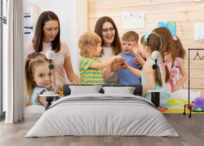 Kindergartener with kids group after lesson in classroom Wall mural