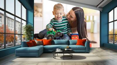 Mother and her toddler son plays with car in their living room Wall mural