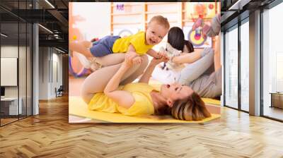 Yoga for babies. Child-friendly fitness for women with kids toddlers. Lifestyle concept of parent activity with children. Wall mural