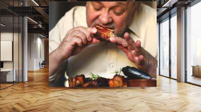 Selective focus. Macro. Man eating barbecue ribs. Steak house. Grilled meat. Wall mural