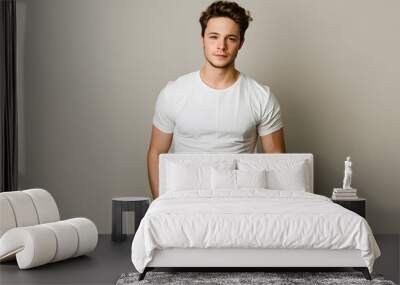 Young handsome man model in white t-shirt posing on light grey background Wall mural