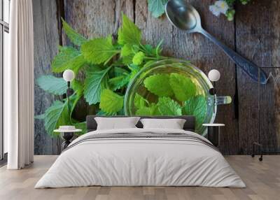 Lemon balm hot herbs tea with fresh leaves on wooden background Wall mural