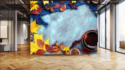 autumn leaves, cup of tea and scarf on blue background Wall mural