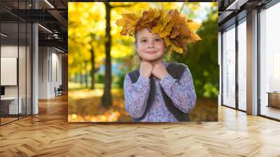 Adorable little girl with autumn leaves in the beauty park Wall mural