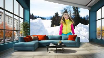 Little smiling girl has fun witn snow outdoors Wall mural