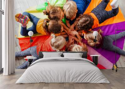 Cheerful children playing team building games on a floor Wall mural