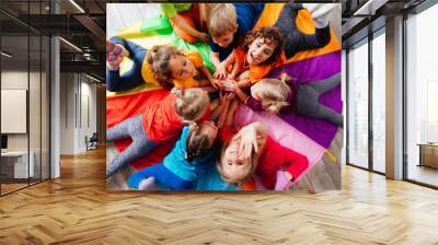 Cheerful children playing team building games on a floor Wall mural