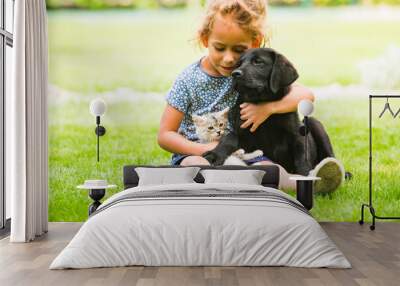 Little girl taking care of her dog and cat Wall mural