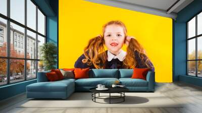 Pretty schoolgirl with two tails wears school uniform over yellow backgounrd Wall mural