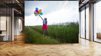 Storm in the field and teenage girl with balloons Wall mural