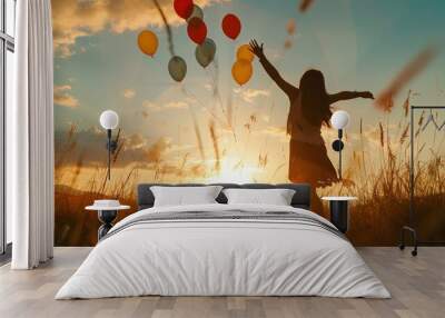 woman holding balloons in the sky at sunset Wall mural